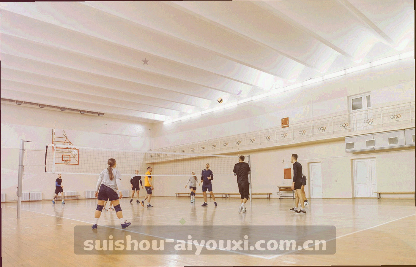 赛前热身时的场地一角，球员背影虚化，傍晚侧光斜切入画面